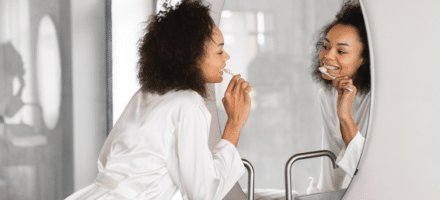 Woman brushing her teeth after getting dental hygiene tips.